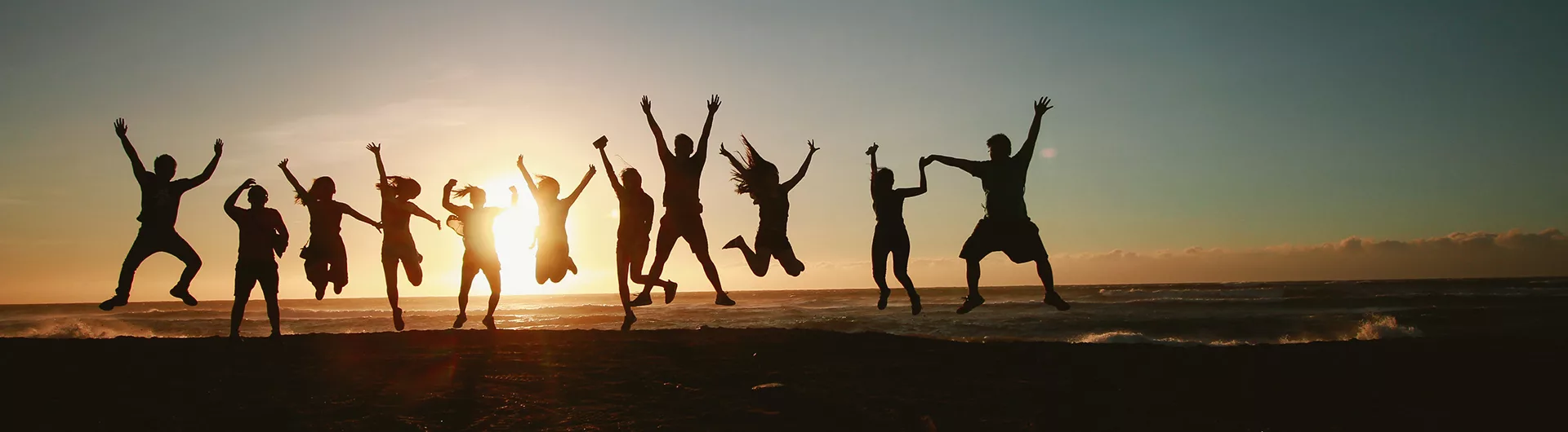 people jumping backlit by a sunset