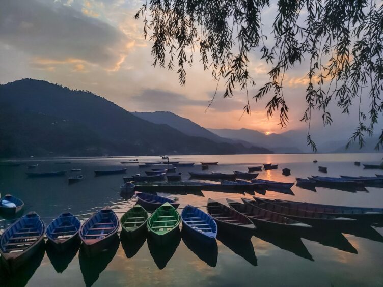A perfect sunset view from Fewa Lake Pokhara Nepal where boats are ready to welcome guests.